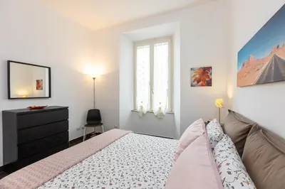 a bedroom with a bed and a dresser and a window at Tasso by Rental in Rome in Rome
