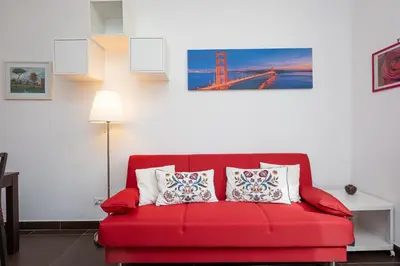 a red couch with two pillows in a living room at Tasso by Rental in Rome in Rome