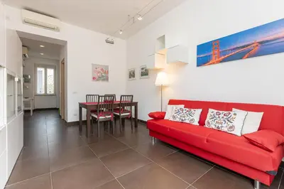 a living room with a red couch and a table at Tasso by Rental in Rome in Rome