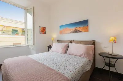 a white bedroom with a bed and a window at Tasso by Rental in Rome in Rome