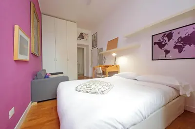 a bedroom with a large white bed and purple walls at San Pietro Al Vaticano by Halldis in Rome