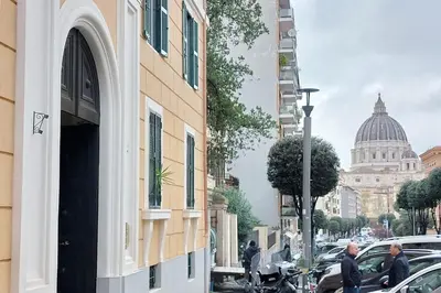a view of a street with a building and a dome at San Pietro Al Vaticano by Halldis in Rome