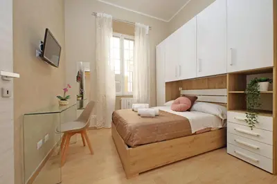 a bedroom with a bed and a desk with a chair at Julius House in Rome