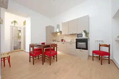 a kitchen with a wooden table and red chairs at Julius House in Rome