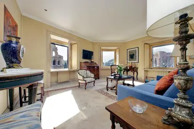 a living room with a blue couch and a table at Colosseo Way in Rome