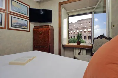 a bedroom with a bed and a window with a building at Colosseo Way in Rome