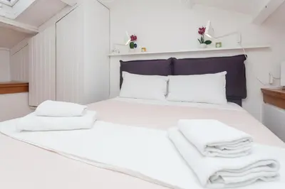 a bedroom with a bed with white sheets and towels at Prati Belfiore Guesthouse in Rome