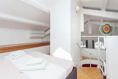 a white room with a bed and a mirror at Prati Belfiore Guesthouse in Rome