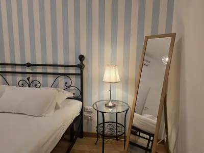 a bedroom with a bed and a mirror and a lamp at Be Your Home - MR House in Rome