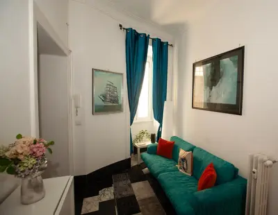 a living room with a green couch and a window at Three sisters- La casa nel Cuore di Roma in Rome