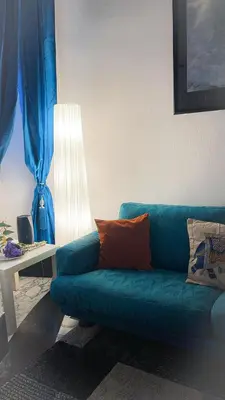 a blue couch sitting in a living room with a lamp at Three sisters- La casa nel Cuore di Roma in Rome