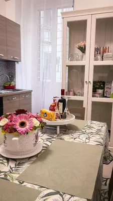 a kitchen with a table with flowers on it at Three sisters- La casa nel Cuore di Roma in Rome