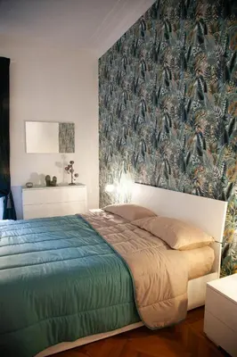 a bedroom with a large bed with a wallpaper at Three sisters- La casa nel Cuore di Roma in Rome