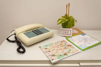 a phone on a table with a map and a book at TESTACCIO XIX-XXV Bed & Breakfast in Rome