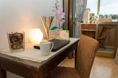a desk with a laptop and a cup on it at TESTACCIO XIX-XXV Bed & Breakfast in Rome