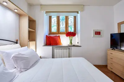 a bedroom with a white bed and a window at Central Suite Navona Campo de Fiori IREX Apartment in Rome