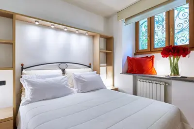a kitchen and living room with a table and a couch at Central Suite Navona Campo de Fiori IREX Apartment in Rome