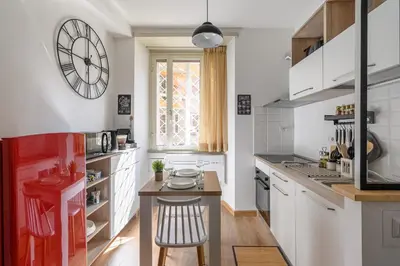 a kitchen with a table and a clock on the wall at Casa Camilla al Vaticano in Rome
