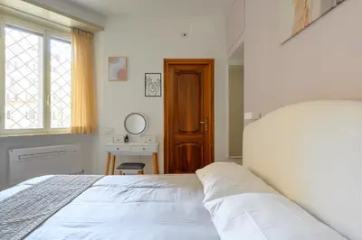 a bedroom with a bed and a table and a window at Casa Camilla al Vaticano in Rome