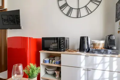 a kitchen with a microwave and a clock on the wall at Casa Camilla al Vaticano in Rome