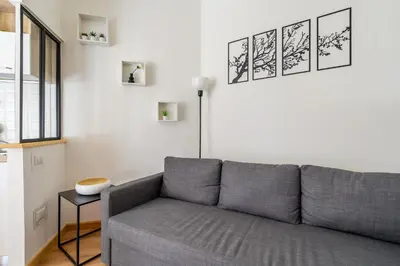 a living room with a gray couch and a window at Casa Camilla al Vaticano in Rome