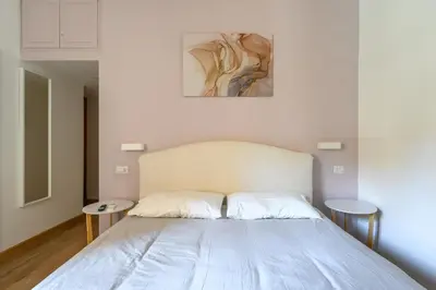a bedroom with a white bed with two tables at Casa Camilla al Vaticano in Rome