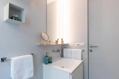 a white bathroom with a sink and a mirror at Cantoni 4A - Loft at Colosseum in Rome