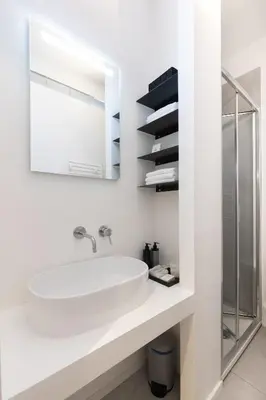 a white bathroom with a sink and a mirror at Cantoni 4B - Studio at Colosseum in Rome