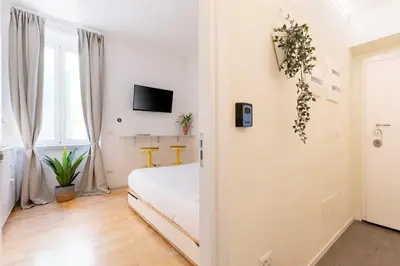 a white room with a bed and a tv at Cantoni 4B - Studio at Colosseum in Rome