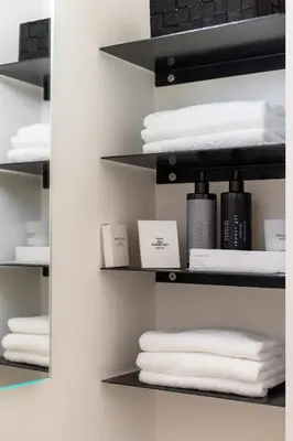 a closet with white towels on black shelves at Cantoni 4B - Studio at Colosseum in Rome