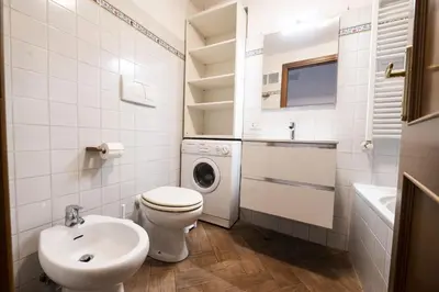 a bathroom with a toilet sink and a washing machine at Campo de Fiori Large Family Apartment in Rome
