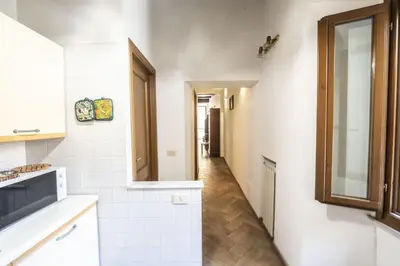 a kitchen with white walls and a hallway at Campo de Fiori Large Family Apartment in Rome