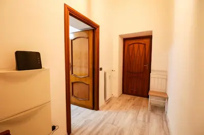 a hallway with a wooden door and a mirror at Casa Angelina - Appartamento zona SanGiovanni in Rome