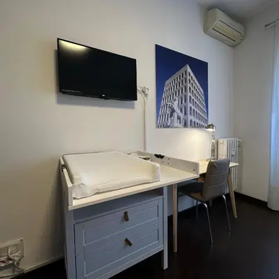 a room with a desk and a tv on the wall at Aniene GH in Rome