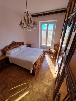 a bedroom with a bed and a chandelier at Appartamento-Castro Pretorio in Rome
