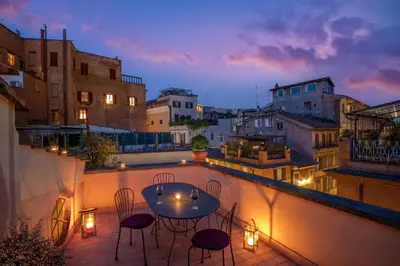 a patio with a table and chairs on a balcony at Maison Medusa in Rome