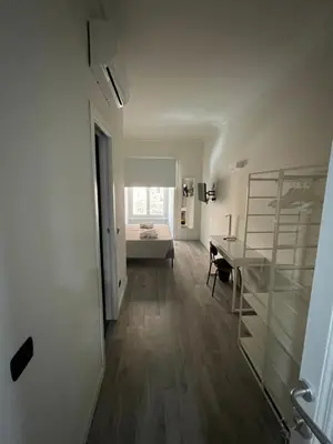 a hallway with a desk and a room with a bed at This must be the place Rome Guesthouse in Rome