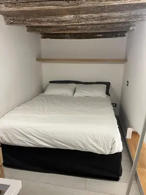 a bedroom with a bed with white sheets at Loft a piazza di Spagna in Rome