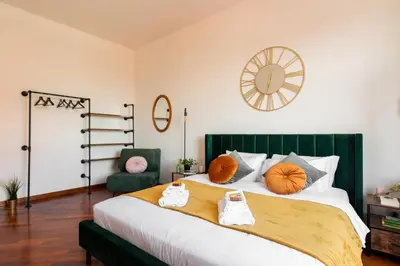 a bedroom with a large bed with a green headboard at Piacentino Homes San Giovanni apartment in Rome