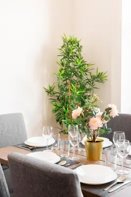 a table with plates and glasses and a plant at Piacentino Homes San Giovanni apartment in Rome