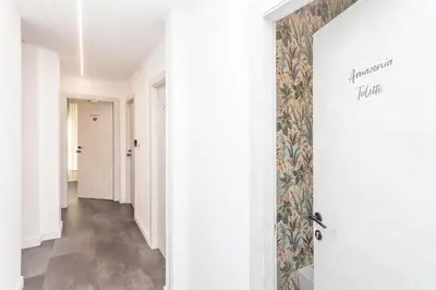a hallway with a white door and a tile floor at Fiorini - Rooms in Rome