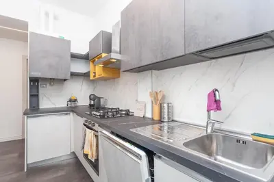 a kitchen with stainless steel appliances and a sink at Fiorini - Rooms in Rome