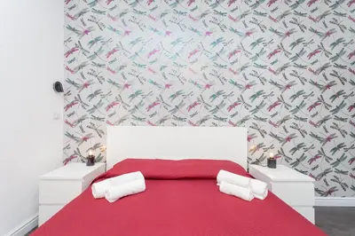 a bedroom with a red bed with a red blanket at Fiorini - Rooms in Rome