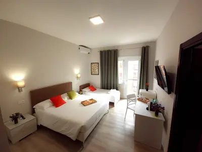 a hotel room with two beds and a television at Piol Guest House in Rome