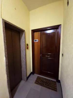 a hallway with a wooden door and a tile floor at Piol Guest House in Rome