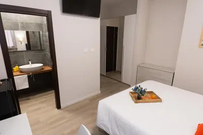 a room with a bed and a bathroom with a sink at Piol Guest House in Rome
