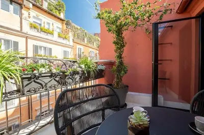 a balcony with a table and chairs and plants at Acque Romane Piazza di Spagna in Rome