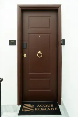 a brown door with a welcome mat in front of it at Acque Romane Piazza di Spagna in Rome