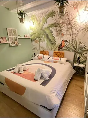 a bedroom with a large bed with a tropical wallpaper at Vita lenta Roma Pigneto terrazza in Rome