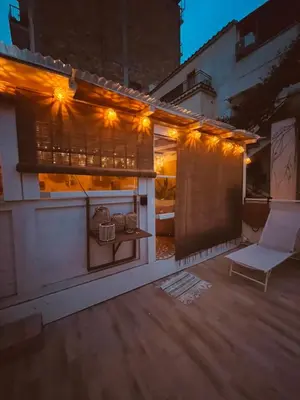 a patio with a chair and a table with lights at Vita lenta Roma Pigneto terrazza in Rome